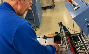 man putting leaflets in folding machine